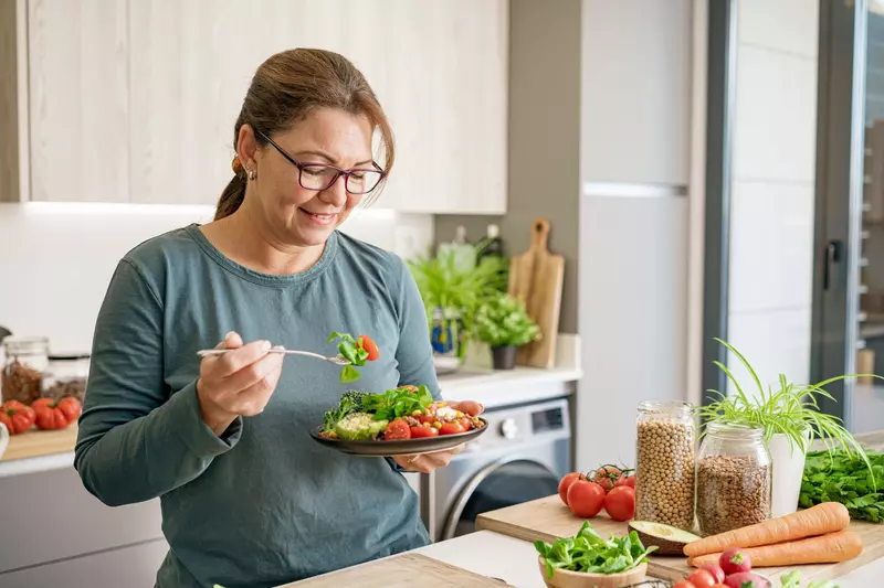 A woman eating a health plant-based meal.