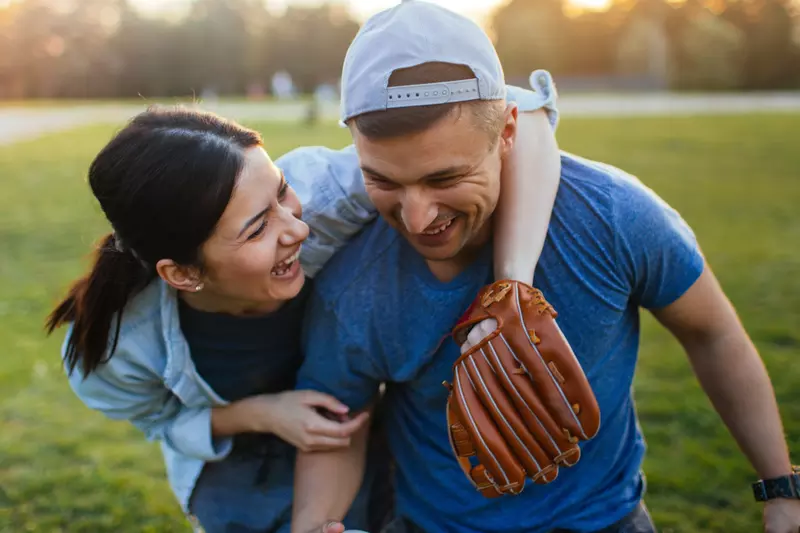 A woman and a man hugging on a baseball field.