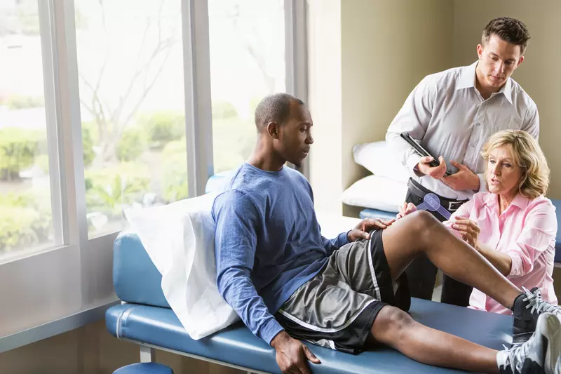 A Sports Medicine Patient is Seen by a Physician While a Resident Takes Notes
