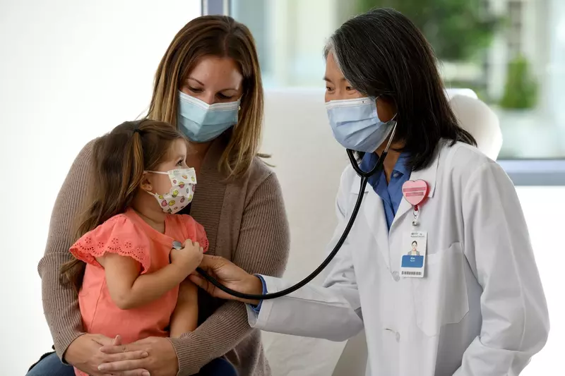 Doctor checking child's hearbeat