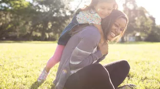 Daughter climbing on her Mother