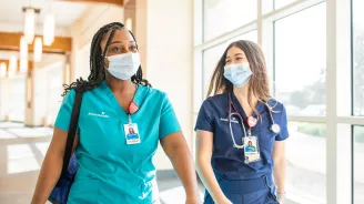 Two nurses walking in a hallway