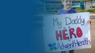 child holding sign outside hospital, AdventHealth Foundation COVID-19