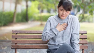 Woman experiencing heart burn in a park