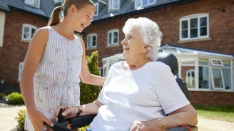 A grandmother plays with her grandchild in her power scooter.