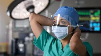 Surgeon putting on mask