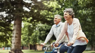 Older couple riding bicycles outdoors.