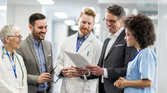 Physicians smiling and talking in hospital hallway