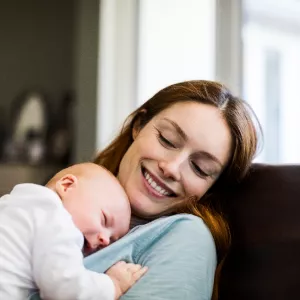 woman holding infant and smiling