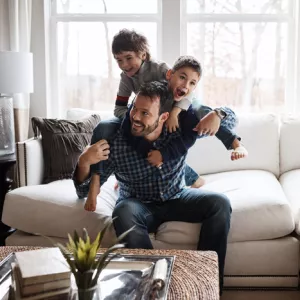 A father playing with his two children.