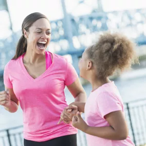 Mother and daughter holding hands for pink run