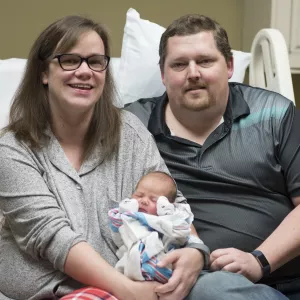 mother and father holding a baby