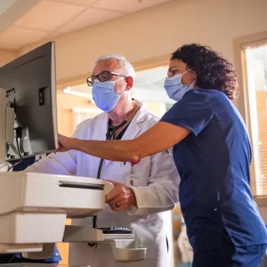 A nurse pointing at a computer screen