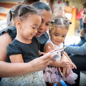 A mother having her young child use a medical test device