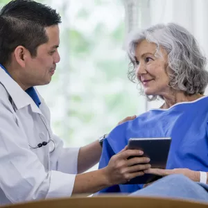 A male doctor and a senior woman patient, consulting.