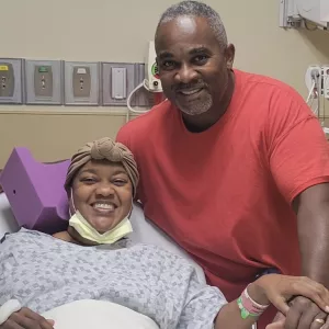 Charlie Simmons in the hospital with her husband by her side