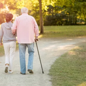 An older couple walking outdoors in the late afternoon