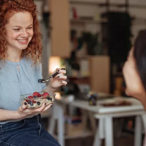 A Young Woman Eating Healthy Foods Like Berries and Oatmeal