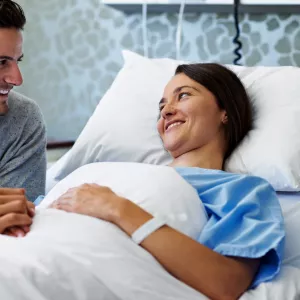 A couple holds hands while in the hospital.