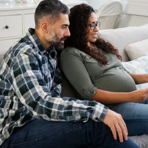 An expecting couple doing a video chat.