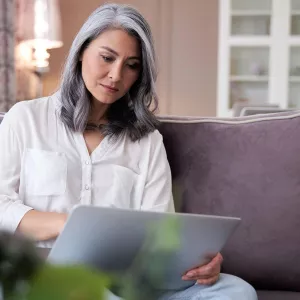 A woman indoors and on her laptop