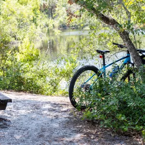 A man prays while sitting on a picnic table.