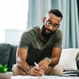 A man writes a list at home while he's quarantined