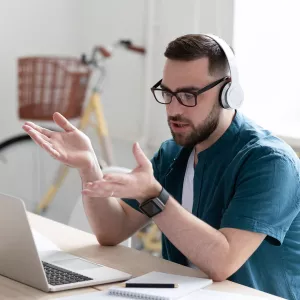 An adult man talks to his work team using a remote meeting