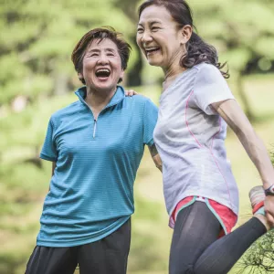 Two women laughing together while spending time outside.