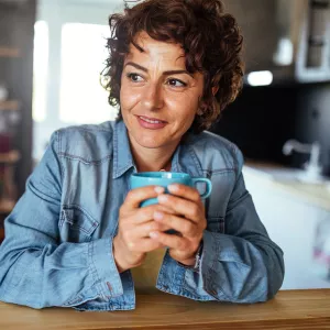 A woman drinking tea at home.