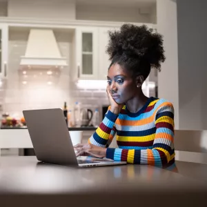 A woman in her living room and on her computer