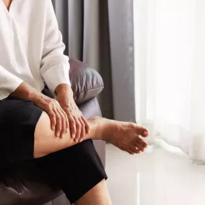 A woman massages her lower legs to relieve the pain