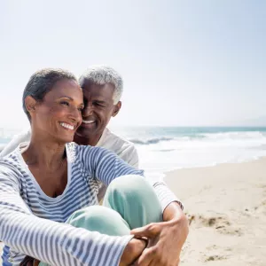 A man and a woman are sitting on the beach.