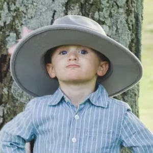 Jax Warren standing in front of tree with large hat