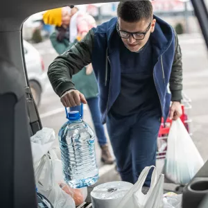 Man loading supplies into a car.