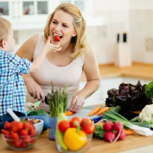 Mom eating strawberries with son.