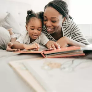 A mother reading to her daughter. 