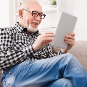 Older man reading on electronic device