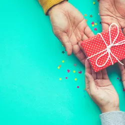 Overhead image of hands giving a gift.