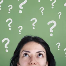 A woman looks upward, with question marks floating above her.