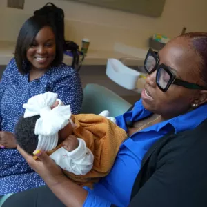 Care coordinator Erike King holds Eliza Gordon's baby girl Trinity.