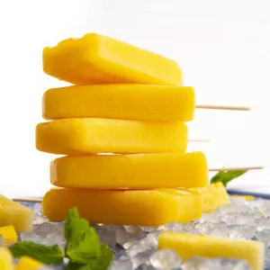 Stack of five orange-colored popsicles on ice