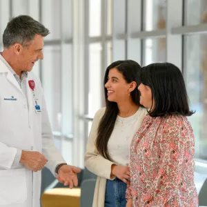 Male physician speaking with two female patients