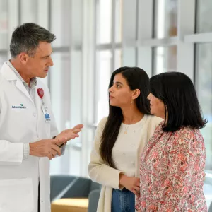 Male doctor speaking with two female patients.