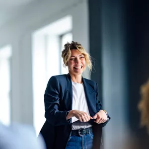 confident smiling woman presenting to goup