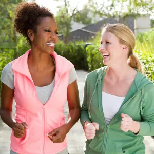 Two women discuss health on a walk outside.