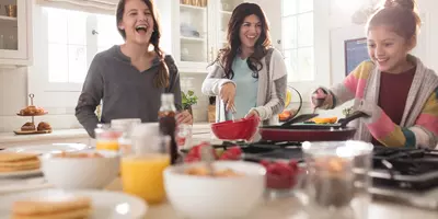 Mother with her daughters cooking in the kitchen.