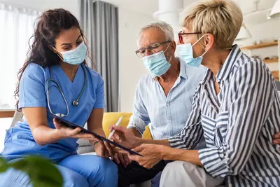 Nurse goes over information with a patient and their spouse.