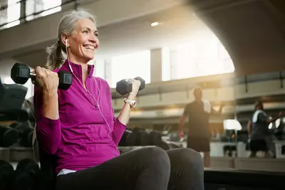 A Senior Woman Works Out at the Gym with a Smile on Her Face