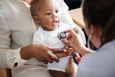 A Physician Checks a Smiling Baby's Breathing with a Stethoscope